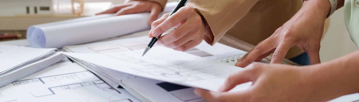 Side view of two people looking at blueprints