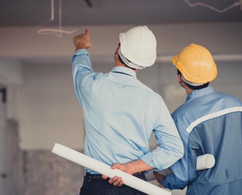 Back view of two contractors at a construction site